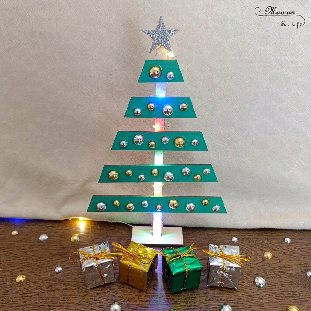 Fabriquer un sapin de Noël lumineux en bois : activité créative et manuelle enfants -Le tutoriel et tout le matériel vient de chez 10 Doigts - Sapin en bois, cabochons dorés et argentés, strass, peinture, mini cadeaux, guirlande lumineuse - Bricolage, DIY, décoration de Noël Fait maison - Kit tout compris - Thème Noël, hiver- Bricolage sympa et facile - Arts visuels Maternelle et cycle 2 - Maternelle et élémentaire - Créativité - Cycle 1 ou 2 - tutoriel photos - mslf