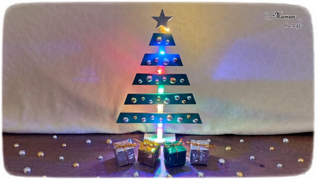 Fabriquer un sapin de Noël lumineux en bois : activité créative et manuelle enfants -Le tutoriel et tout le matériel vient de chez 10 Doigts - Sapin en bois, cabochons dorés et argentés, strass, peinture, mini cadeaux, guirlande lumineuse - Bricolage, DIY, décoration de Noël Fait maison - Kit tout compris - Thème Noël, hiver- Bricolage sympa et facile - Arts visuels Maternelle et cycle 2 - Maternelle et élémentaire - Créativité - Cycle 1 ou 2 - tutoriel photos - mslf