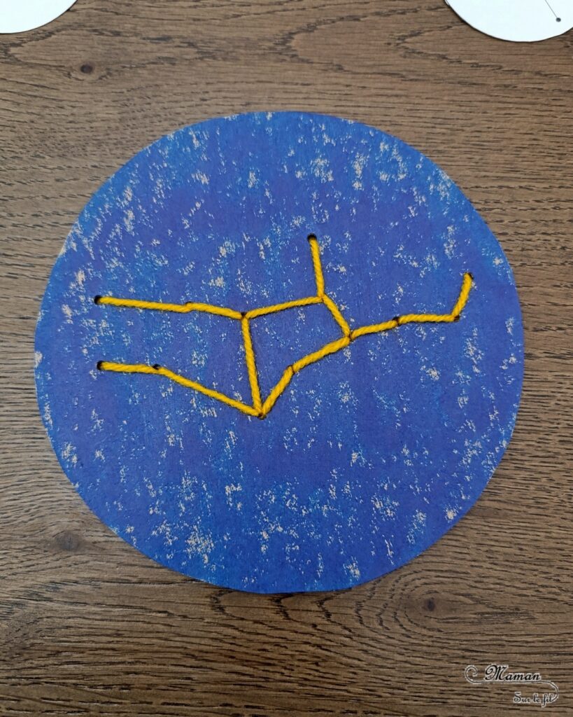 Broder des constellations avec de la laine et du carton : activité créative, récup' et manuelle enfants - Cercles en carton de récup' peint en bleu - Recyclage, surcyclage - Peinture, compas, géométrie, découpage - Trous dans le carton à la perforatrice - Reproduire les constellations avec un modèles avec de la laine et une aiguille - Initiation à la broderie, à la couture Motricité fine - Thème nuit, étoiles, espace - Bricolage et décoration sympa et facile - Arts visuels Maternelle et cycle 2 - Maternelle et élémentaire - Créativité - Cycle 1 ou 2 - tutoriel photos - mslf