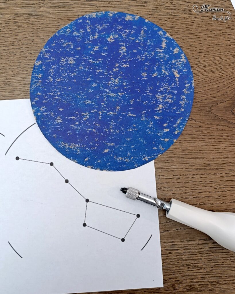 Broder des constellations avec de la laine et du carton : activité créative, récup' et manuelle enfants - Cercles en carton de récup' peint en bleu - Recyclage, surcyclage - Peinture, compas, géométrie, découpage - Trous dans le carton à la perforatrice - Reproduire les constellations avec un modèles avec de la laine et une aiguille - Initiation à la broderie, à la couture Motricité fine - Thème nuit, étoiles, espace - Bricolage et décoration sympa et facile - Arts visuels Maternelle et cycle 2 - Maternelle et élémentaire - Créativité - Cycle 1 ou 2 - tutoriel photos - mslf