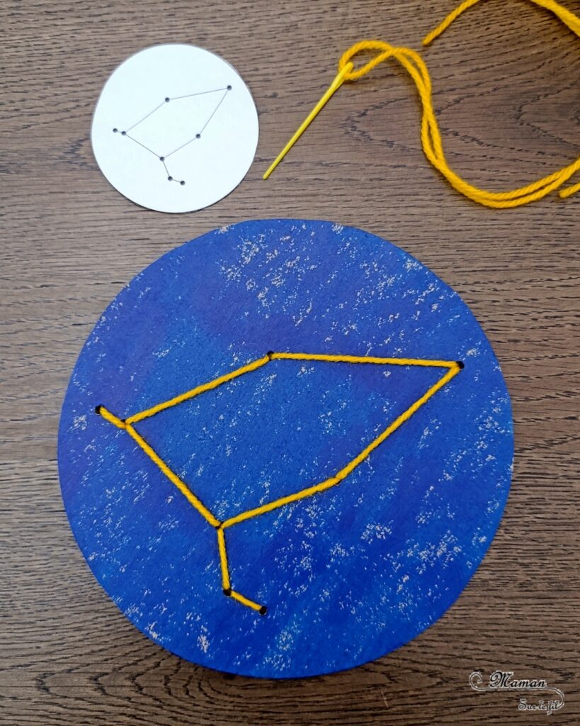 Broder des constellations avec de la laine et du carton : activité créative, récup' et manuelle enfants - Cercles en carton de récup' peint en bleu - Recyclage, surcyclage - Peinture, compas, géométrie, découpage - Trous dans le carton à la perforatrice - Reproduire les constellations avec un modèles avec de la laine et une aiguille - Initiation à la broderie, à la couture Motricité fine - Thème nuit, étoiles, espace - Bricolage et décoration sympa et facile - Arts visuels Maternelle et cycle 2 - Maternelle et élémentaire - Créativité - Cycle 1 ou 2 - tutoriel photos - mslf