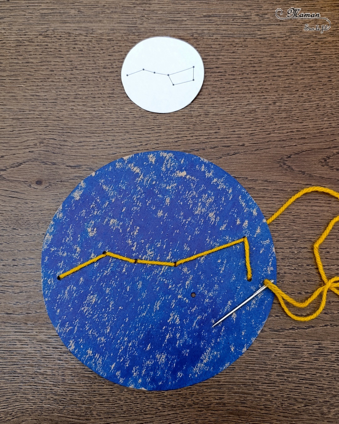 Broder des constellations avec de la laine et du carton : activité créative, récup' et manuelle enfants - Cercles en carton de récup' peint en bleu - Recyclage, surcyclage - Peinture, compas, géométrie, découpage - Trous dans le carton à la perforatrice - Reproduire les constellations avec un modèles avec de la laine et une aiguille - Initiation à la broderie, à la couture Motricité fine - Thème nuit, étoiles, espace - Bricolage et décoration sympa et facile - Arts visuels Maternelle et cycle 2 - Maternelle et élémentaire - Créativité - Cycle 1 ou 2 - tutoriel photos - mslf